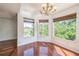 Dining area featuring hardwood floors and a chandelier, illuminated by natural light at 7716 Nottinghill Sky Dr, Apollo Beach, FL 33572