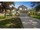 Two-story home with a well-manicured lawn, garden, and a two-car garage at 7716 Nottinghill Sky Dr, Apollo Beach, FL 33572