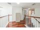 Hallway featuring hardwood floors and white railings at 7716 Nottinghill Sky Dr, Apollo Beach, FL 33572