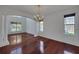 Spacious living room featuring hardwood floors, arched entrance, and decorative pillars at 7716 Nottinghill Sky Dr, Apollo Beach, FL 33572