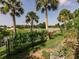 Scenic backyard featuring a lush lawn, palm trees, and a tranquil water view at 1244 E Corktree Cir, Port Charlotte, FL 33952