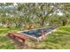 Outdoor bocce ball court with benches, located on a well-maintained lawn under mature trees at 1244 E Corktree Cir, Port Charlotte, FL 33952