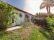 Exterior view of the home with a well-maintained lawn and mature trees at 1244 E Corktree Cir, Port Charlotte, FL 33952