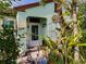 Charming front entrance with vibrant plants and landscaping; bright and inviting with unique decor at 1244 E Corktree Cir, Port Charlotte, FL 33952