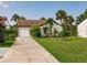 Charming single-story home with well-manicured lawn, mature landscaping, and a convenient attached garage at 1244 E Corktree Cir, Port Charlotte, FL 33952