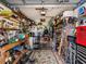 Cluttered garage with storage shelves, a refrigerator, a ladder, and a workbench at 1244 E Corktree Cir, Port Charlotte, FL 33952