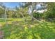 playground featuring swings and a slide in a grassy, shaded area at 1244 E Corktree Cir, Port Charlotte, FL 33952