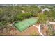 Aerial view of the tennis court with professional fencing and mature trees at 1244 E Corktree Cir, Port Charlotte, FL 33952
