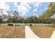 Outdoor tennis court with professional fencing and mature trees beyond at 1244 E Corktree Cir, Port Charlotte, FL 33952