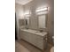 Bright bathroom featuring a double granite vanity with modern lighting and tile floor at 4307 Bayside Village Dr # 103, Tampa, FL 33615
