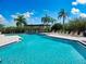 Community pool area featuring ample lounge chairs, a covered seating area, and tropical landscaping at 4307 Bayside Village Dr # 103, Tampa, FL 33615