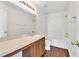 Bathroom with wood cabinets, large mirror, tub, and updated fixtures at 5145 Prairie View Way, Wesley Chapel, FL 33545