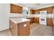 The kitchen has a breakfast bar, wood cabinets, white appliances and tile floors at 5145 Prairie View Way, Wesley Chapel, FL 33545