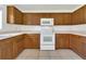Bright kitchen with white appliances, wood cabinets, tile floor, and plenty of countertop space at 5145 Prairie View Way, Wesley Chapel, FL 33545