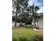 Home featuring a fenced yard with mature palm trees and lawn at 9504 W Cluster Ave, Tampa, FL 33615