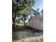 The side and back of the property shows sandy area and established perimeter trees at 9504 W Cluster Ave, Tampa, FL 33615