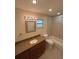 Well-lit bathroom featuring granite countertops, neutral tile and updated fixtures at 9504 W Cluster Ave, Tampa, FL 33615