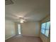 Bright carpeted bedroom with ceiling fan and natural light from two windows at 9504 W Cluster Ave, Tampa, FL 33615