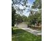 Single-story home featuring an attached two-car garage and long driveway surrounded by mature trees at 9504 W Cluster Ave, Tampa, FL 33615
