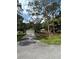 Front exterior showcases a paved driveway, well-maintained lawn, and mature shade trees at 9504 W Cluster Ave, Tampa, FL 33615