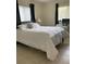 Well-lit bedroom featuring a comfortable bed, a desk, and neutral-toned decor at 1409 Yorkshire St, Port Charlotte, FL 33952