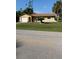 A charming single story home with a well-manicured front lawn and mature landscaping at 1409 Yorkshire St, Port Charlotte, FL 33952