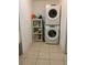 Laundry room with stacked washer and dryer and shelving for cleaning supplies at 1409 Yorkshire St, Port Charlotte, FL 33952