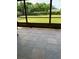 View of a screened patio showcasing an outdoor space with a stone-look tile floor at 1409 Yorkshire St, Port Charlotte, FL 33952