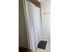 Shower with white curtain, tile surround, towel bar, and gray bathmat at 1409 Yorkshire St, Port Charlotte, FL 33952