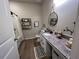 Well-decorated bathroom with shelving, granite countertop, decorative mirror, and a shower with a curtain at 3567 74Th Avenue E Cir, Sarasota, FL 34243