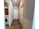 Bright hallway with wood floors, leading to doors and laundry room with modern washer and dryer at 3567 74Th Avenue E Cir, Sarasota, FL 34243