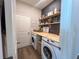 Functional laundry area with modern appliances, wooden countertop and decorative shelves for storage and organization at 3567 74Th Avenue E Cir, Sarasota, FL 34243