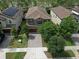 Aerial view showcases a well maintained two-story home with brick driveway and manicured lawn at 12990 Burns Dr, Odessa, FL 33556
