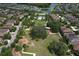 An aerial view of a community park featuring a pool, playground, lush greenery, and walking paths, with neighborhood homes surrounding it at 12990 Burns Dr, Odessa, FL 33556