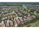 Wide aerial view of homes in a community featuring lakes, green spaces, and a neighborhood pool at 12990 Burns Dr, Odessa, FL 33556