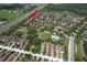 A wide aerial view of a neighborhood that showcases the community park, pool, greenery, and proximity to the nearby highway at 12990 Burns Dr, Odessa, FL 33556