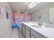 A well-lit bathroom featuring a double vanity, stylish countertops, and a themed shower curtain at 12990 Burns Dr, Odessa, FL 33556