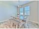 Dining room with stylish table and bench seating beneath modern lighting, complemented by wood-look tile floors at 12990 Burns Dr, Odessa, FL 33556