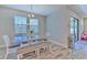 Dining room with stylish table and bench seating beneath modern lighting, complemented by wood-look tile floors at 12990 Burns Dr, Odessa, FL 33556