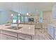 Modern kitchen with granite countertops, stainless sink, pendant lights and a view to the living room at 12990 Burns Dr, Odessa, FL 33556