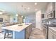Open concept kitchen featuring a center island, stainless steel appliances, and view to the living room at 12990 Burns Dr, Odessa, FL 33556
