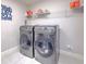 Laundry room with side-by-side washer and dryer, a shelf for storage, and tile flooring at 12990 Burns Dr, Odessa, FL 33556