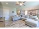 Open concept living room featuring a large sectional sofa, wood-look tile flooring, and view to the kitchen at 12990 Burns Dr, Odessa, FL 33556