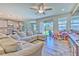 Spacious living room featuring a large sectional sofa, wood-look tile flooring, and view to the backyard at 12990 Burns Dr, Odessa, FL 33556