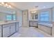 Main bathroom with dual sink vanities, soaking tub, tiled floors, and ample natural light at 12990 Burns Dr, Odessa, FL 33556