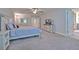 Large main bedroom featuring neutral carpeting, ceiling fan, tv, and a well-lit ensuite bathroom at 12990 Burns Dr, Odessa, FL 33556