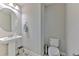 Powder room showcasing pedestal sink, round mirror, and contemporary fixtures at 12990 Burns Dr, Odessa, FL 33556