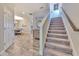 Carpeted staircase leading to the second floor, complemented by wood-look tile flooring in the foyer at 12990 Burns Dr, Odessa, FL 33556
