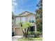 Charming two-story townhome featuring a well-maintained lawn, complemented by two palm trees, and a neutral-toned exterior at 4605 Ashburn Square Dr, Tampa, FL 33610