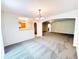 Spacious living area with archways leading to the dining area and kitchen, featuring neutral-colored carpet throughout at 4605 Ashburn Square Dr, Tampa, FL 33610